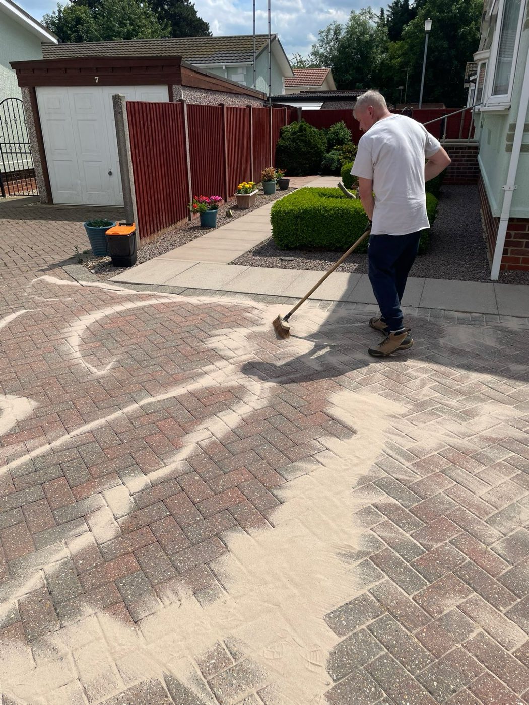 Re-sanding a block-paved driveway in the sun